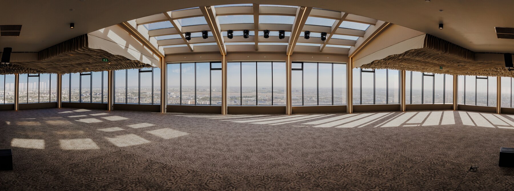 Rooftop Hall — panoramic sweep of the 48th floor event space at golden hour, floor-to-ceiling windows on all sides overlooking Tashkent