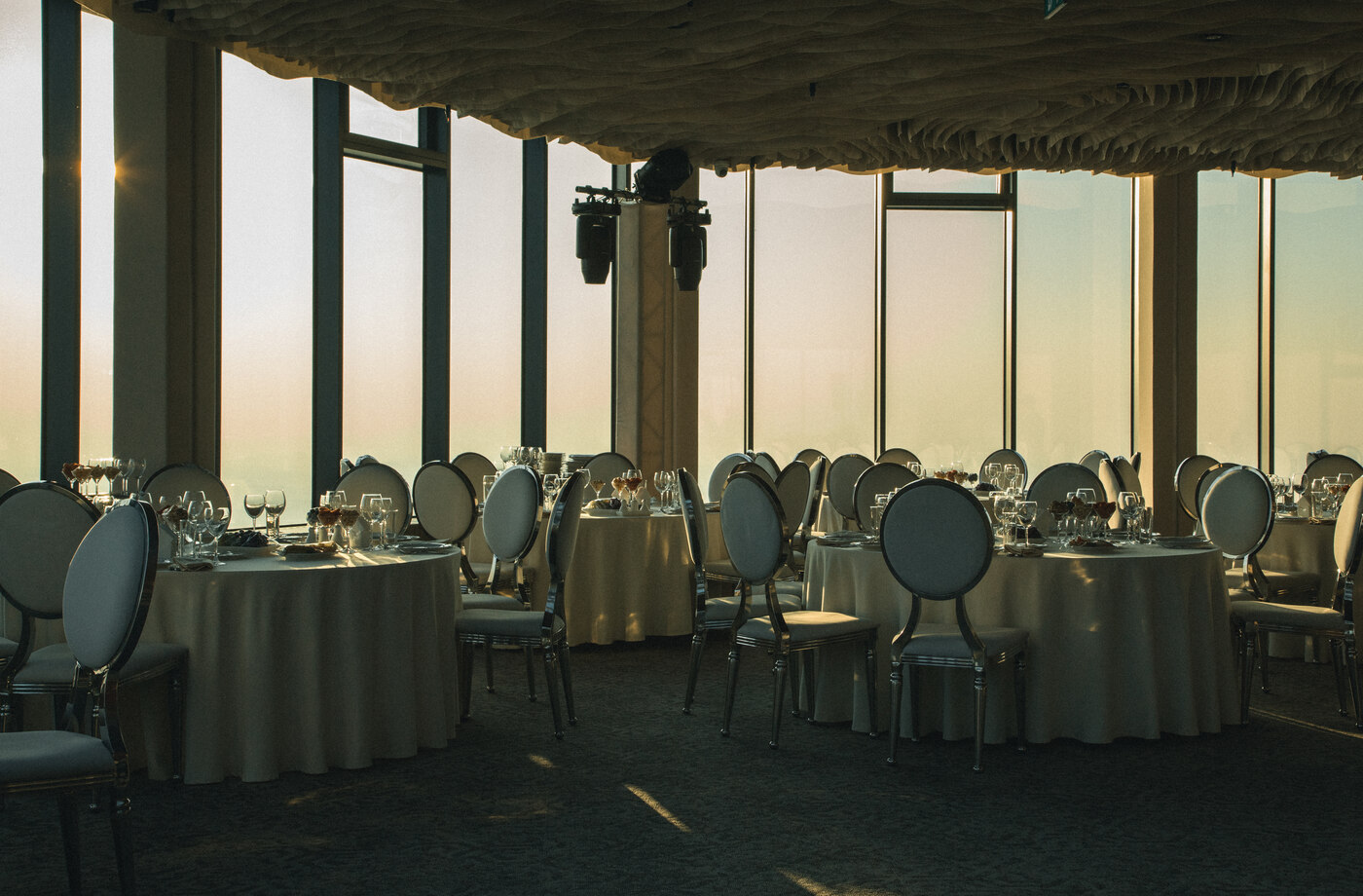Rooftop Hall — banquet tables set for a wedding reception at golden hour, 48th floor