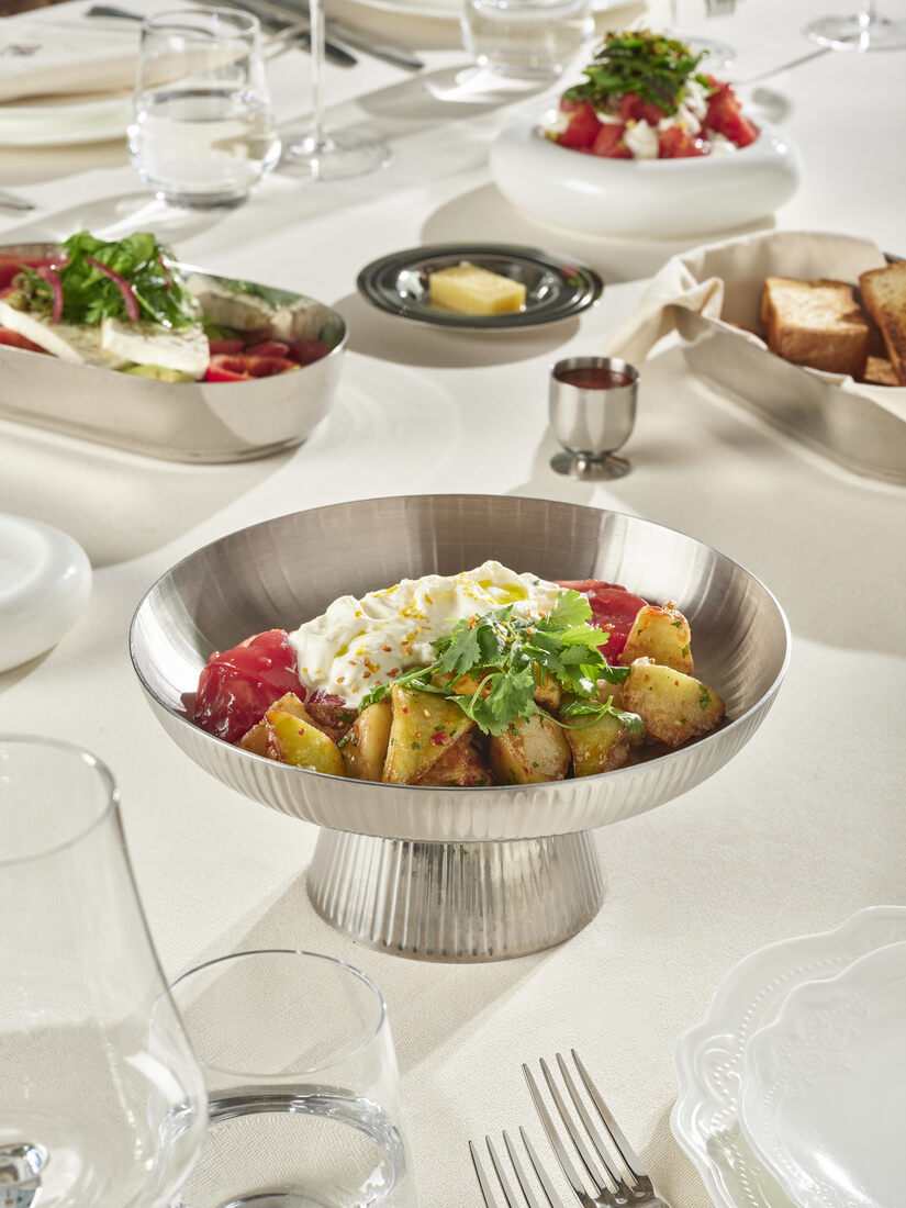 Warm potato preparation in a fluted silver bowl — comfort and craft