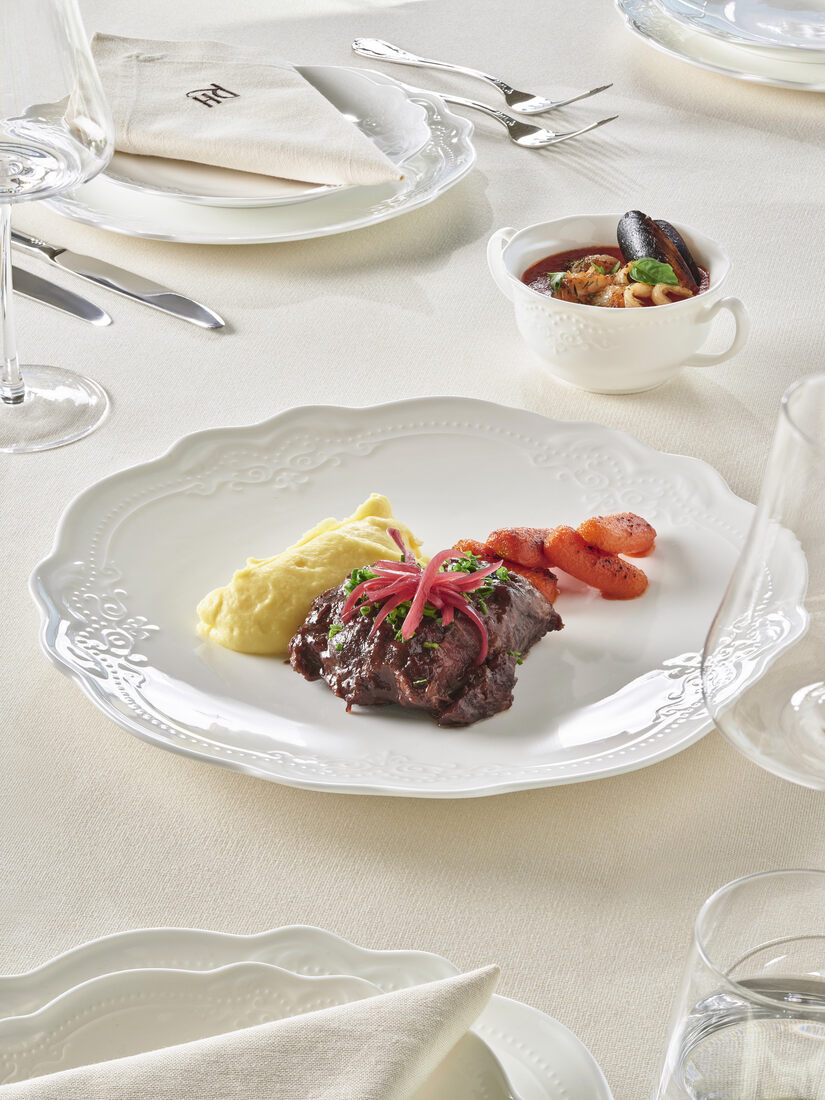 Beef tenderloin with mashed potato, glazed carrots and red onion